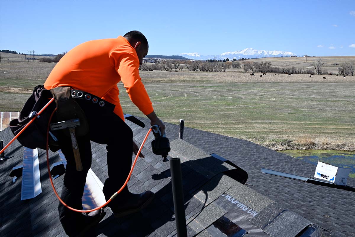 a man using a drill installing shingles